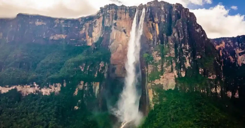 Angel Falls Venezuela wide landscape view with massive waterfall dropping from cliff surrounded by dense rainforest
