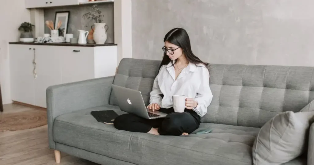 oung professional working remotely from home on laptop under hybrid work model in India